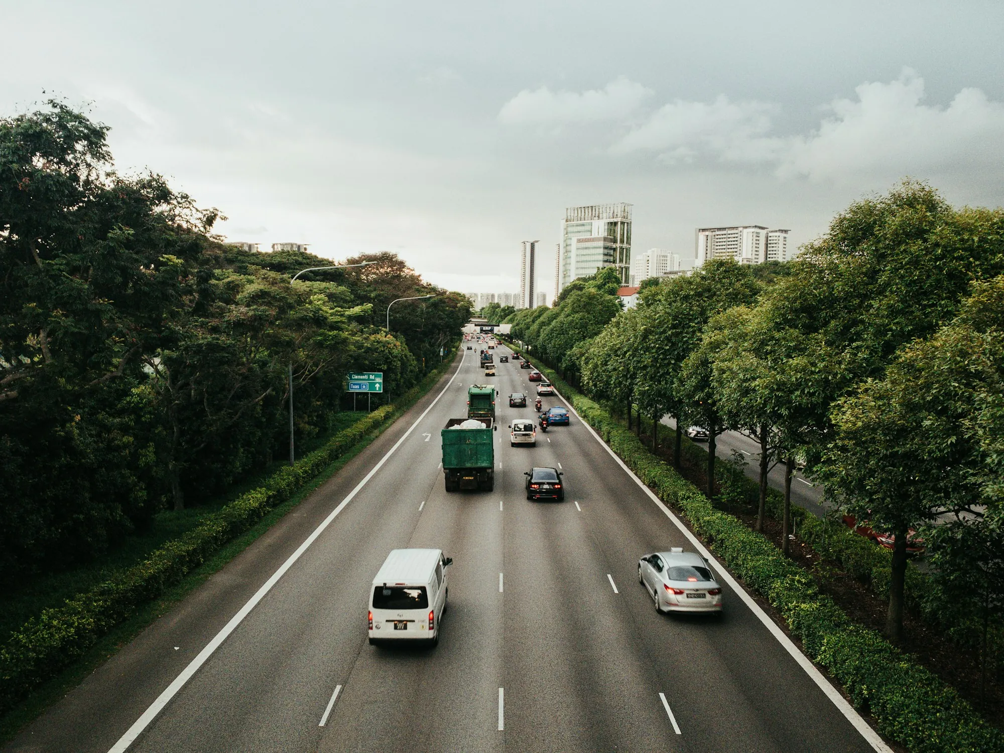 Highway lanes with light traffic and trees on both sides