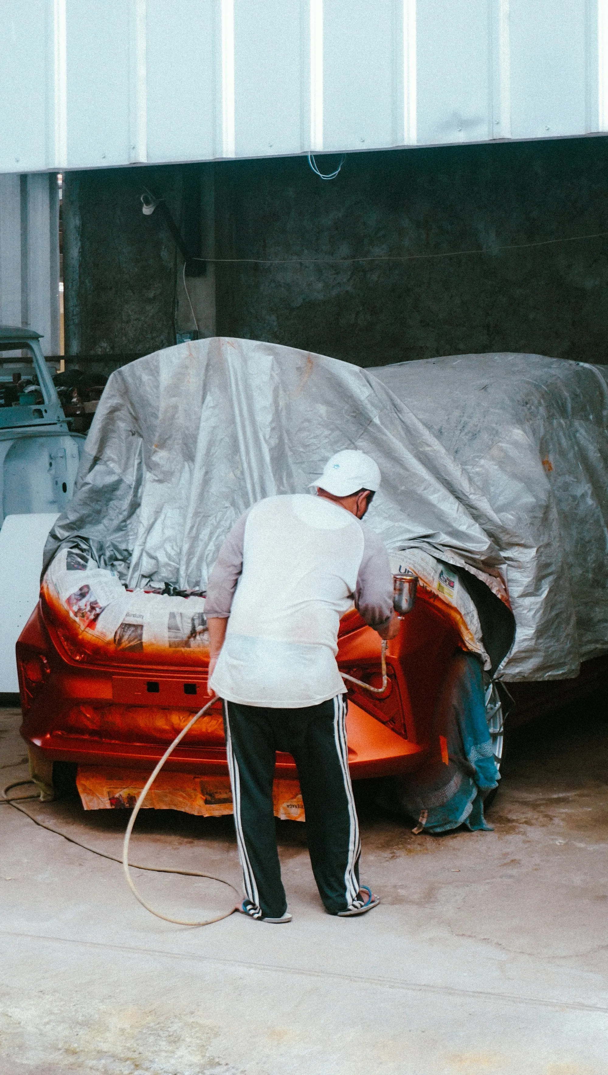 Technician masking a car before painting