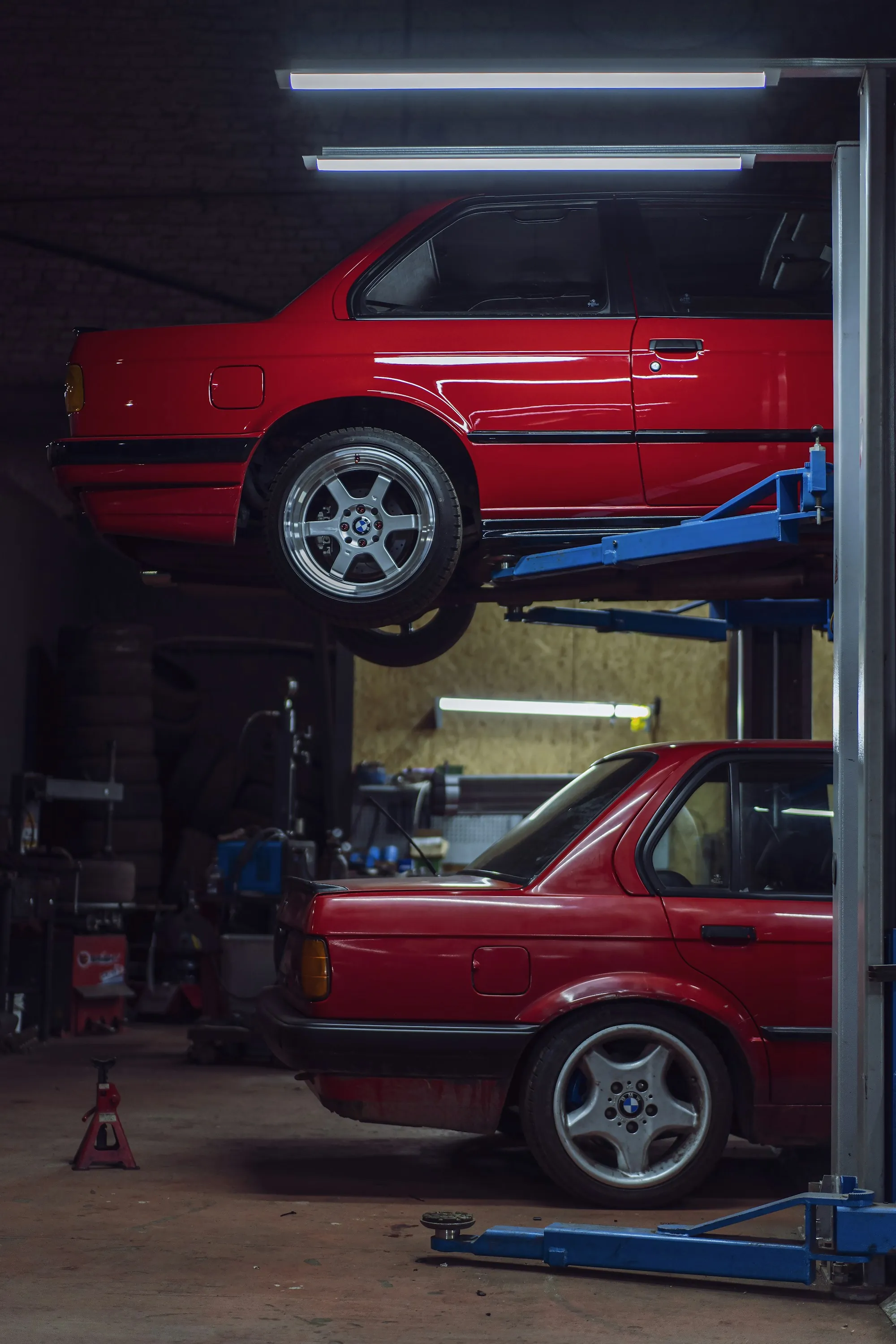 Inside an auto repair workshop with a car on a lift