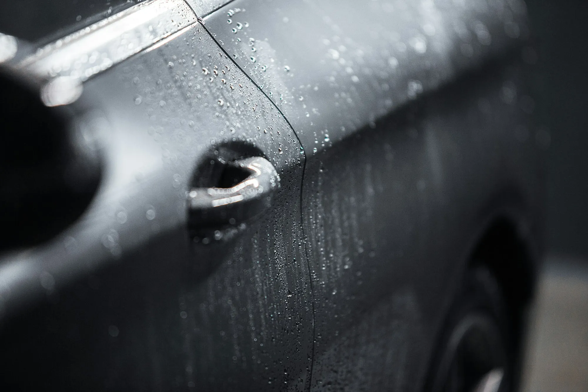 Close view of a long scratch across the rear quarter panel of a red car